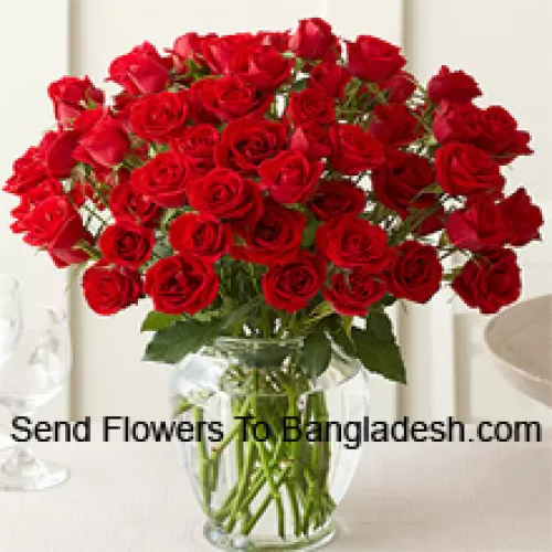50 Roses Rouges Avec Quelques Fougères Dans Un Vase en Verre